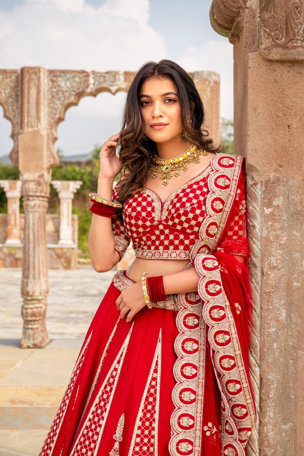 Bright red raw silk bridal lehenga choli with hand cut dana work