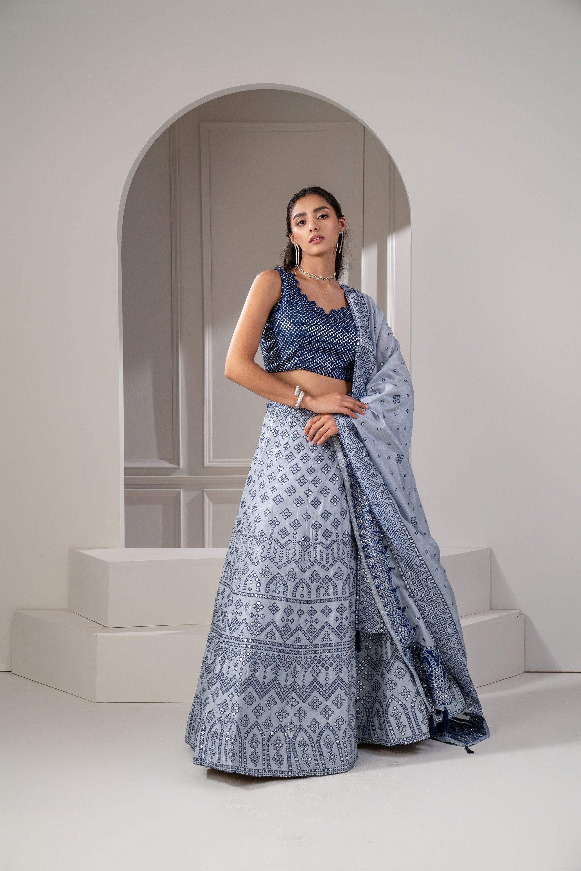 STEEL GREY LEHENGA SET WITH A HALTER NECK BLOUSE AND ALL OVER SILVER ZARI  EMBROIDERY PAIRED WITH A MATCHING EMBROIDERED DUPATTA AND SILVER  EMBELLISHMENTS. - Seasons India